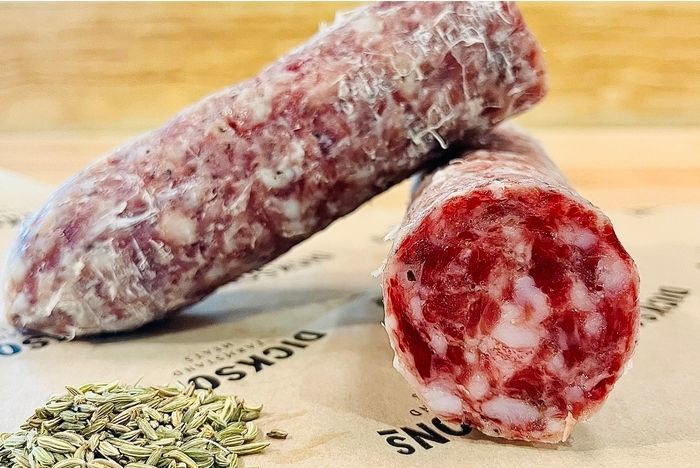 Two pieces of sliced cured sausage with herbs