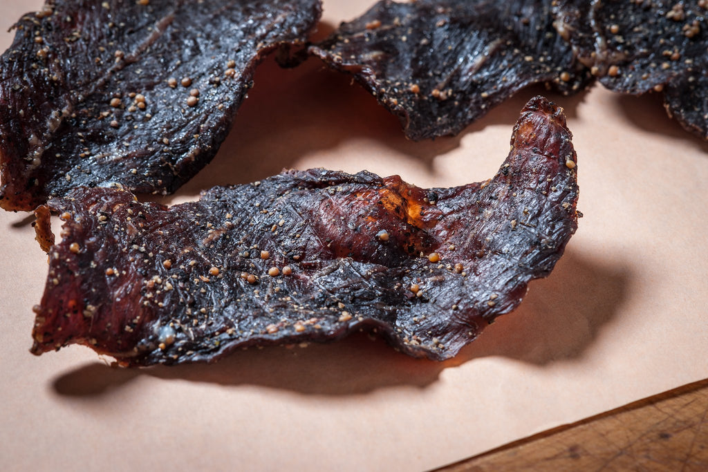 Close-up of pieces of jerky on a parchment background.