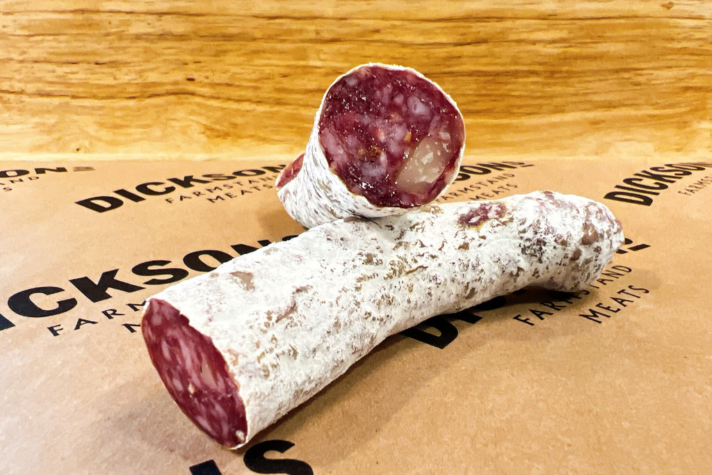 Two pieces of cured sausage on butcher paper.