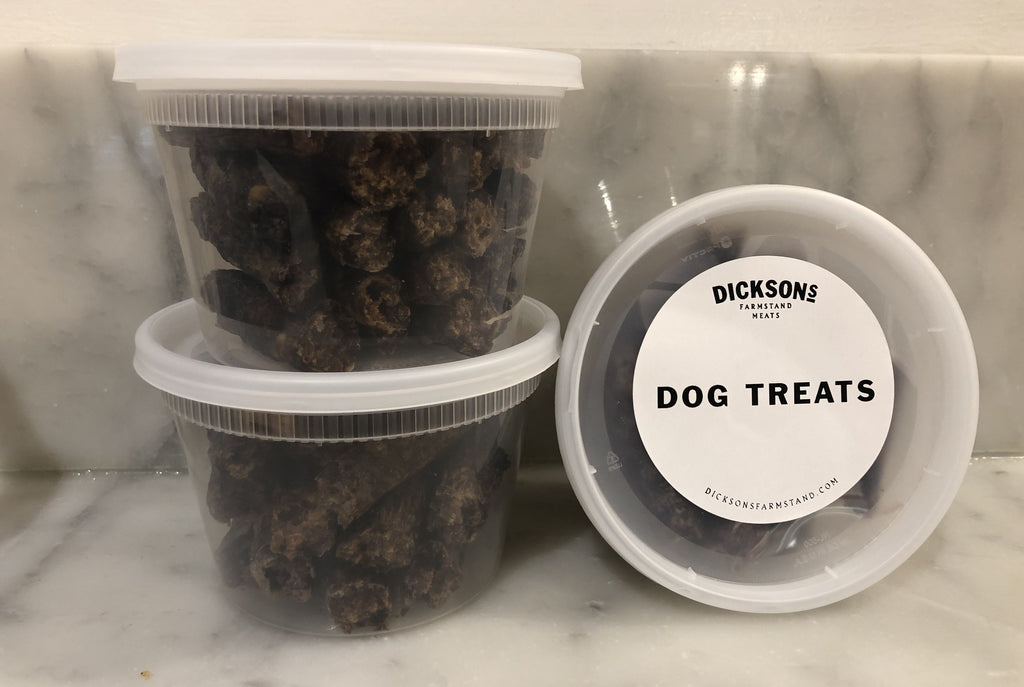 Containers of dog treats on a marble surface