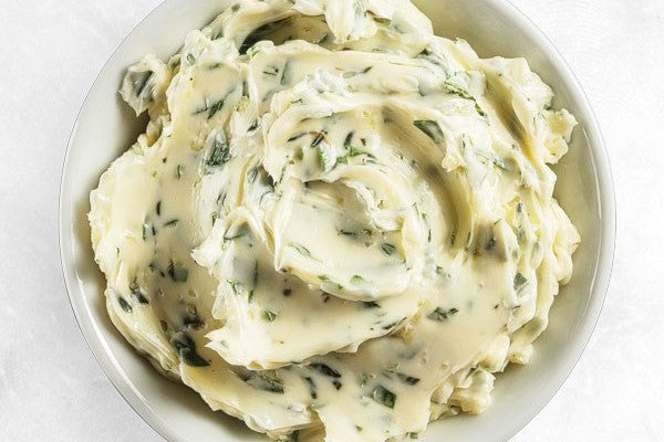 A bowl of creamy herb-infused butter spread.
